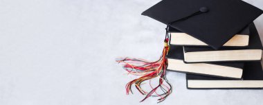 Gri arkaplan web afişi üzerine kitap yığını üzerine mezuniyet başlığı