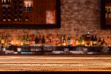 İçi boşaltılmış tuğla duvarlı, likör şişeli boş ahşap tezgah, ürün yerleştirme için kopyalama alanı 