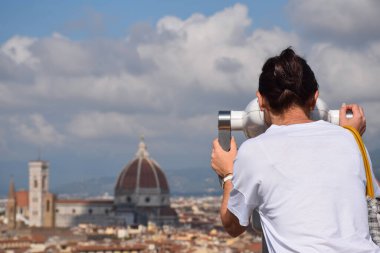 Kadın, Santa Maria del Fiore Duomo Katedrali 'nin manzaralı dürbünlerinden bakıyor. 