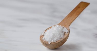 Kapalı makro kabuklu deniz tuzu mermer arka planda tahta bir kaşıkta