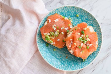 Füme somon sandviçi. Mavi tabakta, üzerinde fotokopi alanı olan simit.