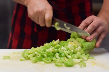 Restoran çalışanı bıçakla kereviz kesiyor.