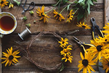 Kırsal kesimde sarı çiçekli çelenk resmi.