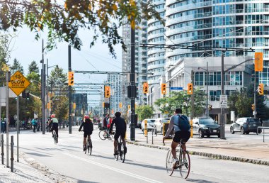 Toronto, Ontario, Kanada - 17 Ekim 2021: Queens Quay limanında bisiklet süren insanlar