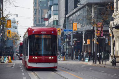 30 Ekim 2022 - Toronto, Ontario, Kanada: King Street West ve John Street 'te Toronto şehir merkezinde kırmızı tramvay