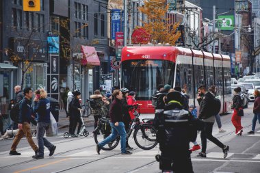 Toronto, Ontario, Kanada - 30 Ekim 2022: Tramvay ve şehir merkezindeki Queen Caddesi 'nden geçen insanlar
