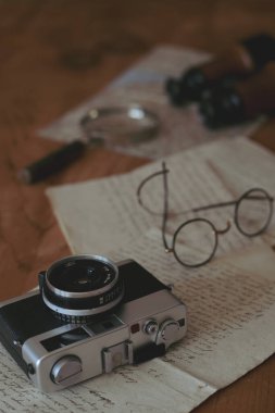 Eski moda film kamerası ve eski el yazısıyla yazılmış mektuplar.