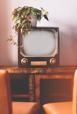 Oturma odasında sandalyeli eski model bir TV.