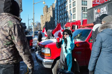 Ottawa, Ontario, Kanada - 5 Şubat 2022: Özgürlük Konvoyunda kahve içen mutlu kadın pandemik kısıtlamalara ve talimatlara karşı protesto