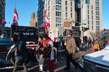 Ottawa, Ontario, Canada - February 5, 2022: Protesters with flags and signs at Freedom Convoy protest against pandemic restrictions and mandates clipart