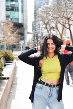 Caddede kameraya bakıp gülümseyen mutlu genç kızın portresi.