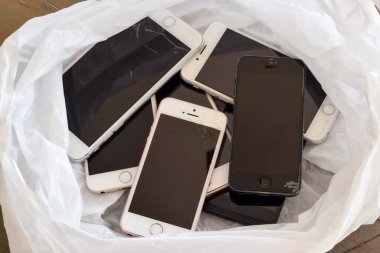 4 Nisan 2025 - Newmarket, Ontario, Kanada: Beyaz bir çöp torbasında eski modası geçmiş iPhone koleksiyonu