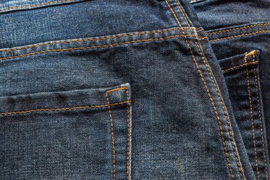 Kapalı mavi kot pantolon, turuncu renkli dikiş ipliği ve arka cebi