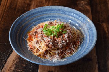 Yeşil lahanayla süslenmiş makarnalı mavi kase.