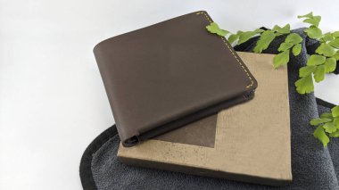 Kahverengi deri ve yeşil yapraklar beyaz arkaplanda