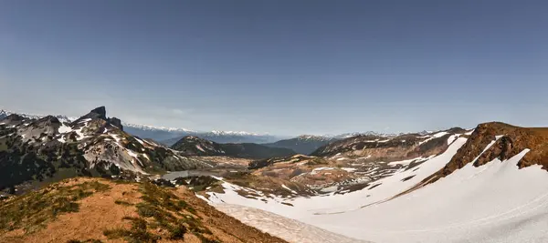 Black Tusk ve British Columbia 'nın etrafındaki buzul vadilerinin geniş panoramik görüntüsü. Bu dağlık arazide engebeli tepeler, karla kaplı yamaçlar ve canlı çayırlar Kanada 'nın el değmemiş vahşi doğasının güzelliğini gözler önüne seriyor..