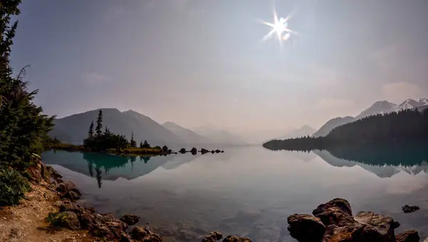 British Columbia 'daki Garibaldi Gölü, kristal berrak sularındaki yüksek dağ tepelerini ve yoğun ormanları yansıtır. Engebeli kıyı şeridi kayaları ve uzak buzullarla çevrelenmiş bu sakin alp gölü Kanada 'nın el değmemiş vahşi doğasını yakalar.. 