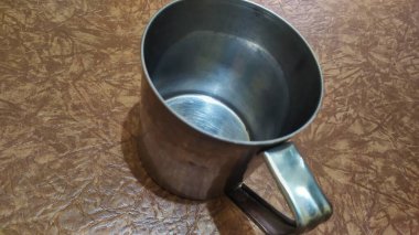 Kahverengi bir tabanda kahve ya da çay için boş bir alüminyum bardak, yakın plan..