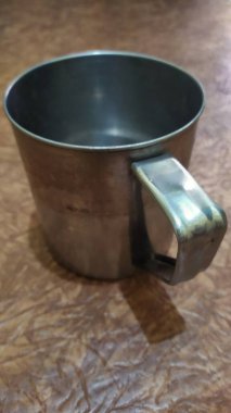 Kahverengi bir tabanda kahve ya da çay için boş bir alüminyum bardak, yakın plan..