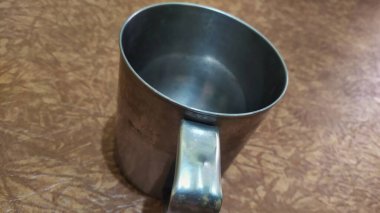 Kahverengi bir tabanda kahve ya da çay için boş bir alüminyum bardak, yakın plan..