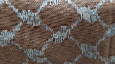 Türban kumaşının dokusu elmas gibi beyaz desenli, arka plan altın sarısı. Yakın plan..