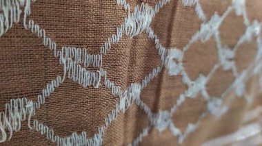 Türban kumaşının dokusu elmas gibi beyaz desenli, arka plan altın sarısı. Yakın plan..