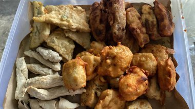 Kavanoz dolusu kızarmış tempeh, kızarmış tofu, yağsız kağıtta kızarmış temppura, üst manzara..