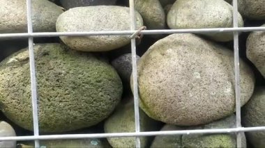 Taşların yan görüntüsü düzenlenmiş ve örülmüş demir tellerle kaplı. Yakın plan..