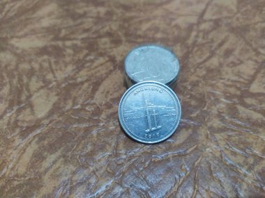 1000 rupiah sikke, Endonezya parası, 1000 rupiaya yakın, Endonezya. Kahverengi hasırda para.