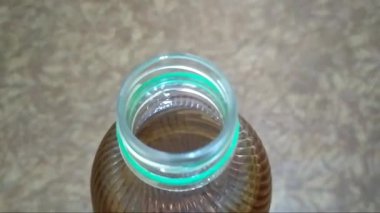 Palmiye yağı plastik şişesi kahverengi arka plan üst görüntü fotoğrafında izole edilmiş. Yiyeceklere yakın çekim. Şişenin içi..