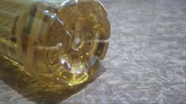 Palmiye yağı plastik şişesi kahverengi arka plan üst görüntü fotoğrafında izole edilmiş. Yiyeceklere yakın çekim. Şişenin dibi..