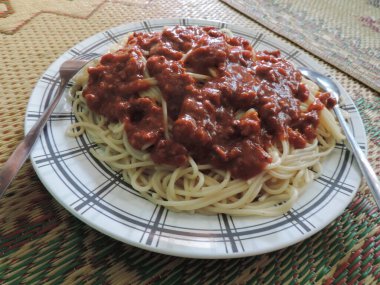 Baharatlı biberli spagetti, plastik tabakta servis edilir..