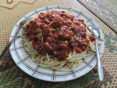 Baharatlı biberli spagetti, plastik tabakta servis edilir..