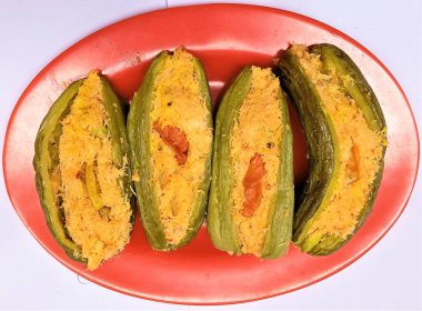 rendelenmiş hindistan cevizi dolgusu artı dilimlenmiş petai ve kırmızı biberli pare (Momordica charantia L.) servis edin.