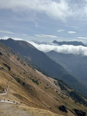 Tatra dağları üzerinde altın yamaçları ve uzak bulutları olan güneşli dağlık bir tepe. Yüksek kalite fotoğraf