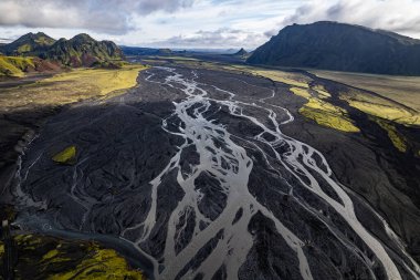 İzlanda 'nın Vik kenti yakınlarındaki Thakgil (Pakgil) yakınlarında yeşil tepeler ve kıvrımlı nehir yatakları arasında bulunan bir havza, seyrek bir yabanın hava aracı görüntüsüne sahiptir. Güzelliği ve yalnızlığı vurguluyorum.