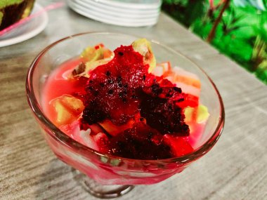 Üzeri meyve, agar agar, hindistan cevizi, ejderha meyvesi ve tatlı sütle karıştırılmış buzlu fotoğraf.