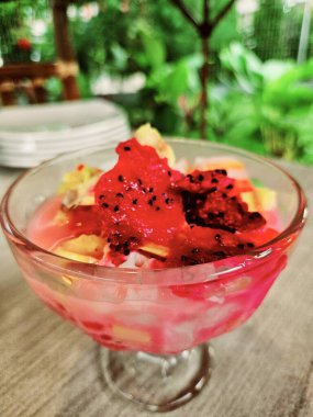 Üzeri meyve, agar agar, hindistan cevizi, ejderha meyvesi ve tatlı sütle karıştırılmış buzlu fotoğraf.