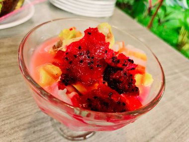 Üzeri meyve, agar agar, hindistan cevizi, ejderha meyvesi ve tatlı sütle karıştırılmış buzlu fotoğraf.