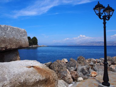 Yunanistan 'ın Korfu kıyı şeridinde bir kaldırımda kayalar ve deniz fenerleri