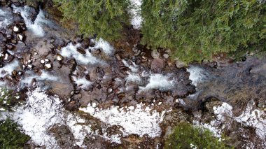 Fotoğraf, vadinin nefes kesen güzelliğini yakalar. Nehir, dağların ve ormanın kalbinde huzur içinde akar.