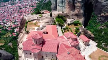 Videoda İHA manastırın üzerinden uçuyor ve izleyicinin dikkatini Kalambaka şehrine çekiyor.