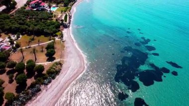 Video, kumsalda uçan bir dron gösteriyor. Güzel manzaralar gösteriyor.