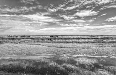 Manzara, güzel siyah beyaz gökyüzü güneş battıktan sonra denizi yansıtır..