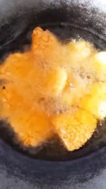 Kızarmış tempo ve taze balık sıcak metal bir tavada kıtır kıtır kızartılıyor. Köpüren yağ, geleneksel yemek pişirme anlarında iştah açıcı bir yemek hazırlama sağlar..