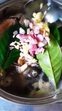 Taze balık, renkli sebzeler ve aromatik bitkiler içeren geleneksel bir pindang yemeği pişirme süreci. İçindekiler lezzetli ve besleyici bir yemek yapmak için bir kaba eklenir..