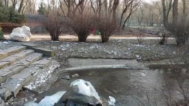 Buzlu kış dokunuşuyla dönüşen doğal bir çeşmenin büyüleyici güzelliğine tanık olun. Doğal harikalar diyarının kalbinde sakin, donmuş bir manzara.