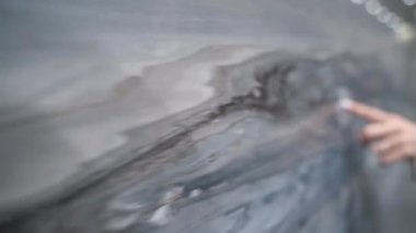 El, desenli mermer bir taş duvarın üzerinde yavaşça süzülüyordu. Detayları ve doğal desenleri gösteriyordu.