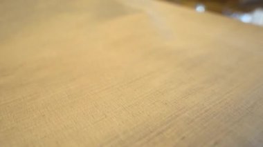 Bej kumaş yakın çekim: yumuşak dokuma dokusu karmaşık yumuşak ışık detaylarıyla yakalanır