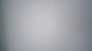 Parlak tırnaklar belirgin bir şekilde açılır. Kalın bir görsel darbe için el değmemiş beyaz bir duvara karşı.